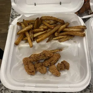 fried chicken and fries in a styrofoam container