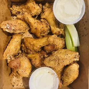 a box of chicken wings with dipping sauce