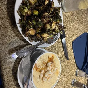 a plate of brussels sprouts and a bowl of soup
