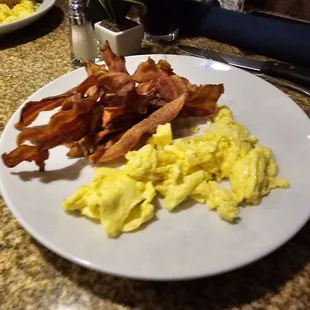 Two eggs scrambled with bacon and wheat toasts