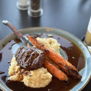 a plate of food with mashed potatoes and carrots
