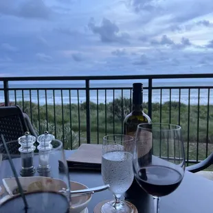 a glass of wine and a bottle of wine on a table