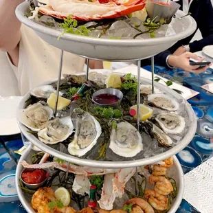 a man taking a picture of a seafood platter