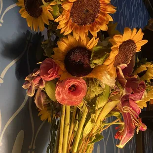 a vase of sunflowers and roses