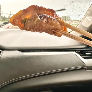 a person holding chopsticks in a car