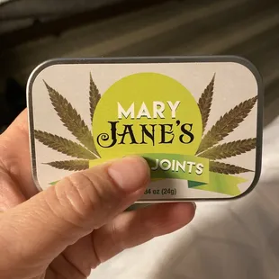 a person holding a tin of mary jane's mints