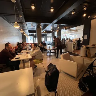 people sitting at tables in a coffee shop