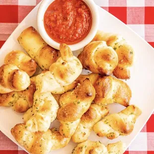 a plate of cheesy pretzels and dipping sauce