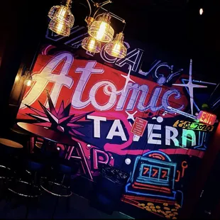 a neon sign for atomic tavern