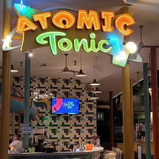 a neon sign above a bar