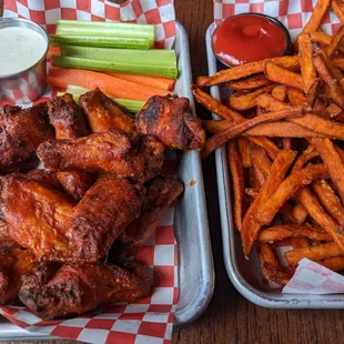 two trays of wings and fries
