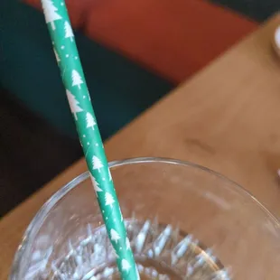 a glass of water with a green straw