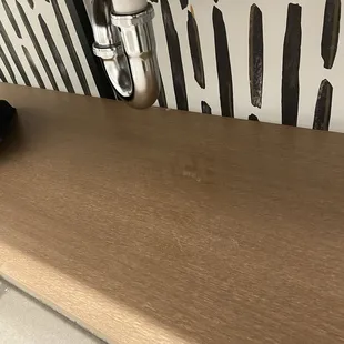 Water leaking from the sink onto the wood below. This hotel is 4 months old-- what happened here?