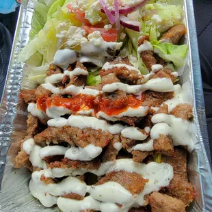 a tray of salad with dressing