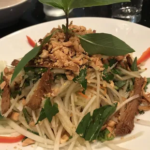 Green papaya salad is a guest favorite, with vegan fish sauce  and tossed with peanuts, Thai basil &amp; vegan housemade beef jerky. A delight!