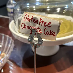 a chocolate cake with a sign that says gluten free chocolate cake