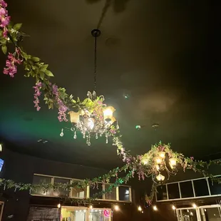 a chandelier with flowers hanging from the ceiling
