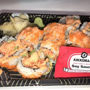 a tray of sushi with a packet of kimkoman soy sauce