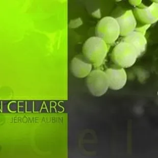 a man smiling in front of a bunch of grapes