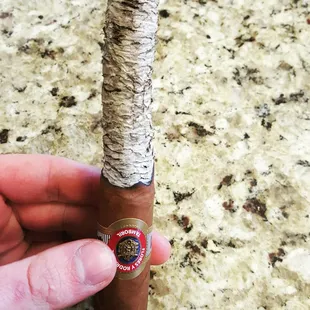 a hand holding a cigar
