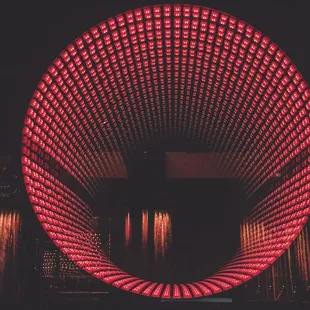 An infinity Mirror adorns the wall behind the Dj's as they play.