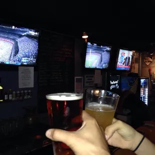 a hand holding a pint of beer