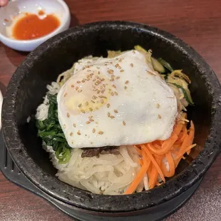 a bowl of food with a fried egg on top