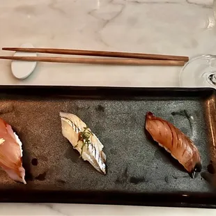 a plate of sushi and chopsticks