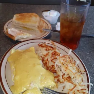 Breakfast. Omlet. Cheese. Mushrooms. Hollandaise sauce. Hashbrowns. Sourdough. Iced tea.