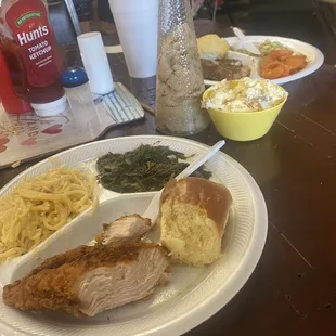 Fried chicken, mustard greens and chicken spaghetti on my plate. Smothered pork chop, Lima beans, and sweet potatoes on friends plate.