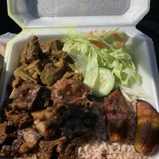 Combo plate of oxtail, curry goat, with rice and peas.