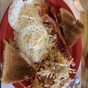 Two eggs over hard, bacon, hash browns, wheat toast