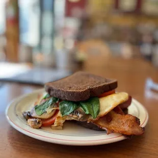 Custom breakfast sandwich. Spinach, tomato, egg over easy, mushrooms, onion! Oops...forgot the cheese! I did, not them!