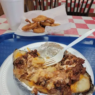Baked potato with chopped barbecue.  Side of onion rings. And large sweet Tea.
