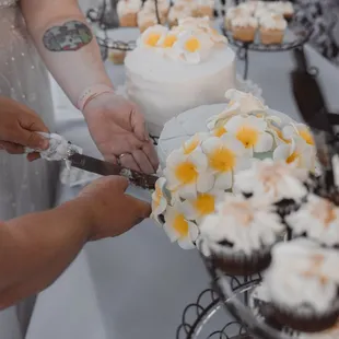 a bride and groom cutting their wedding cake