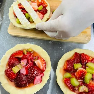 Strawberry Rhubarb pies being topped with a lattice top