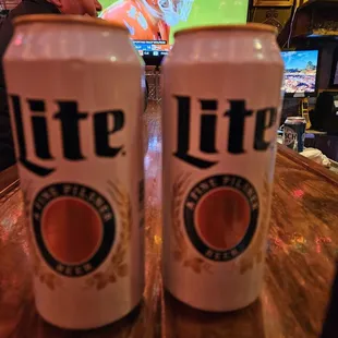 two beer cans on a bar