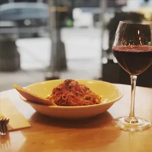 a plate of spaghetti and a glass of wine