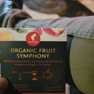 a person holding a box of organic fruit symphony