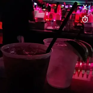 a drink in a plastic cup on a bar counter