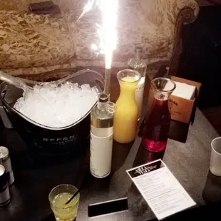 a table with drinks and a lit candle