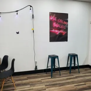 two stools and a neon sign