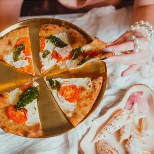 a woman holding a plate with a pizza on it