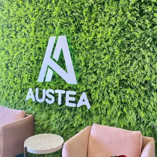a lounge area with a green wall and pink chairs