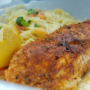 a fish dish with noodles and a lemon