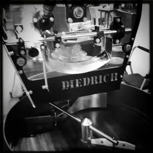 a black and white photo of a roasting machine