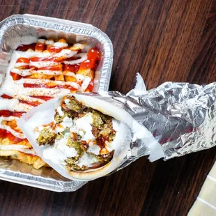  a sandwich wrapped in foil with ketchup and ketchup