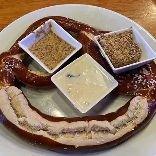 Bavarian pretzel appetizer with queso, stone ground mustard, and beer mustard