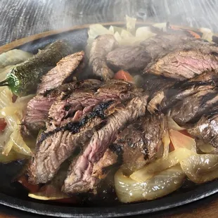 Close up of steaming sizzling beef fajitas