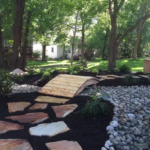 a garden with a wooden bridge